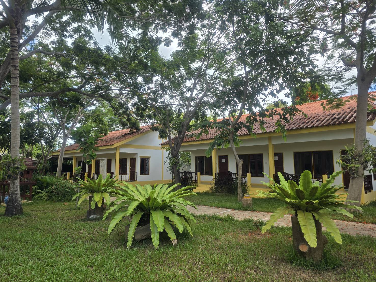 Guest buildings among mature trees and tropical plants